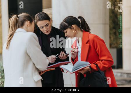Three Businesswomen Collaborating Outdoors with Documents and Notes Stock Photo