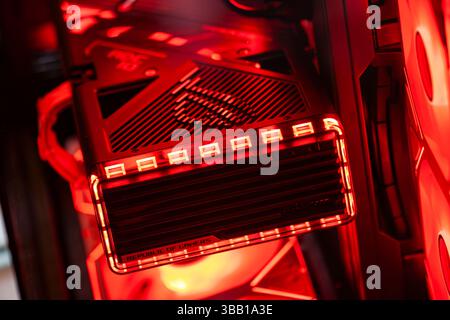 Rome, italy 10 may 2025: red lights illuminate the inside of a custom-built gaming pc, highlighting the powerful republic of gamers motherboard Stock Photo