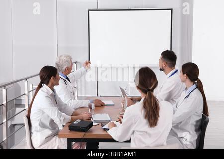 Team of doctors using video projector during conference indoors Stock Photo