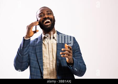 Portrait of happy and successful businessman. Black man in business suit is talking on mobile phone. Stock Photo