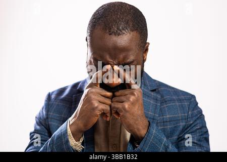 Portrait of tired and exhausted businessman who is having pain in head and sinus. Stock Photo