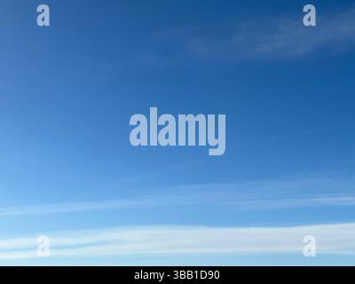 Beautiful blue sky with soft, white clouds, creating a serene atmosphere. Stock Photo