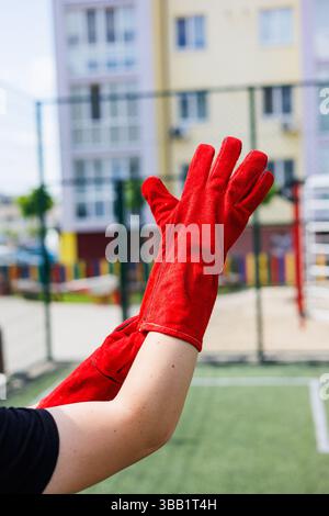 Rough gloves on men's hands for a construction worker. Construction gloves. Durable gloves for dirty work. Rubberized construction gloves. Stock Photo