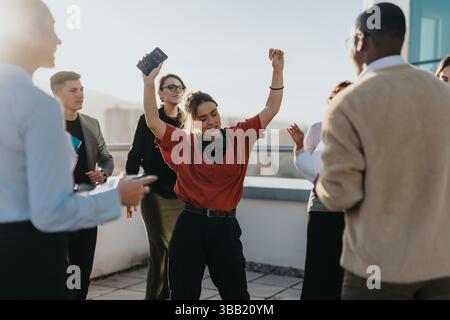 A group of multiracial, business colleagues joyfully celebrate success on a high tower balcony. Stock Photo