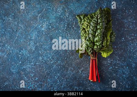Swiss Rainbow chard, silverbeet or mangold over rustic blue textured background Stock Photo