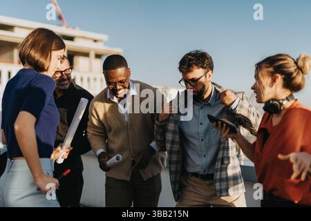 Multicultural business team enjoying rooftop break with music and dance Stock Photo