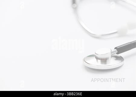 medical concept shot featuring a metallic stethoscope positioned on a clean white surface. The word "APPOINTMENT" is subtly printed in light grey text Stock Photo