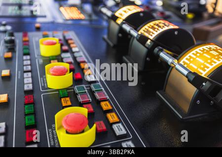 A detailed view of a control panel showcasing illuminated buttons and adjustable handles, suggesting technical or industrial applications. Marine navi Stock Photo