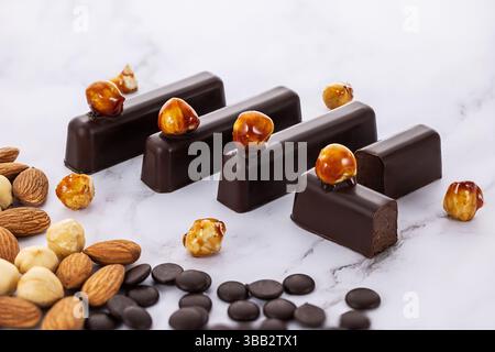 Delicious Chocolate Bars with Hazelnuts on Marble Background Stock Photo
