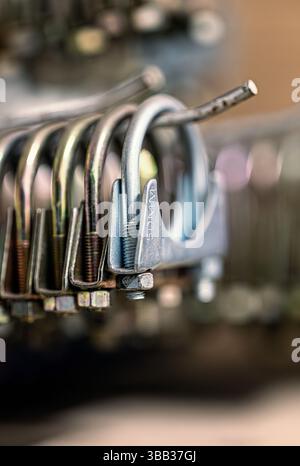A collection of 50mm exhaust clamps hanging on rack in a tyre and exhaust depot. Norfolk, UK Stock Photo