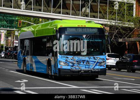 Spokane, WA, USA - May 2, 2025; Spokane Transit Authority New Flyer Industries bus on city street with veterans message Stock Photo