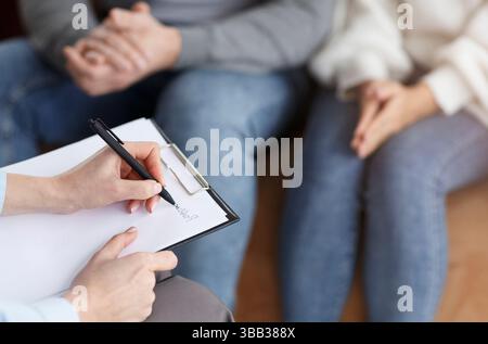 Marriage Consultant Taking Notes Talking With Couple In Office, Cropped Stock Photo