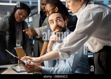 Data center coworkers doing brainstorming, working together to verify neural network parameters. Server hub staff members talking, inspecting configurations to ensure optimal performance Stock Photo