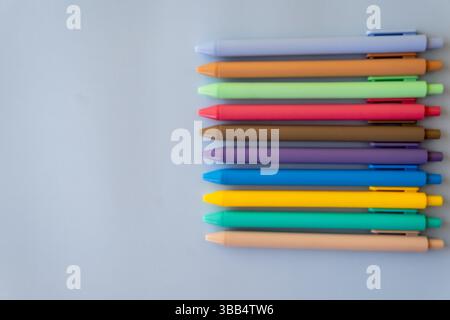 Minimalist composition with colorful ballpoint pens arranged in neat lines on light background symbolizing creative school supplies vibrant Stock Photo