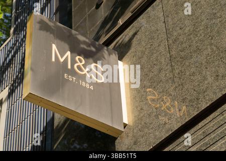 M&S department store logo and branding displayed on the exterior wall above the main entrance of the retail store in London, UK Stock Photo