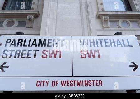 Street sign in Westminster, London, showing Parliament Street SW1 on the left and Whitehall SW1 on the right, road nameplate in UK government district Stock Photo