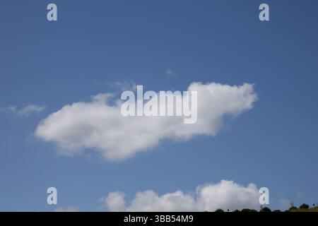 Single White Cloud Floating in a Bright Blue Sky Stock Photo