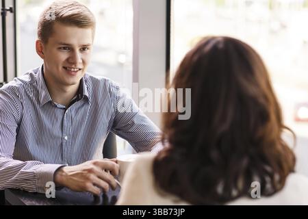 Couple enjoying coffee and talking in cafe Stock Photo