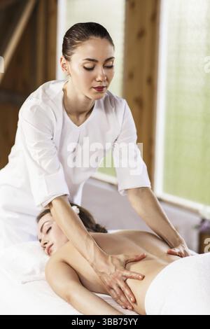 beautiful girl enjoys back massage in spa salon. Procedures for beauty