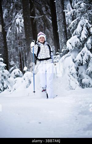 Young woman hiking in a snowy forest Stock Photo