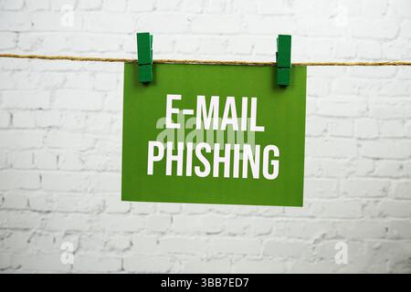 E-mail Phishing text on green paper card hanging with rope on white brick background Stock Photo