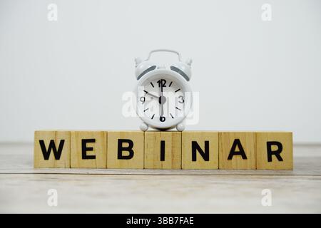 Time to Webinar with wooden blocks alphabet letters and alarm clock on wooden background Stock Photo