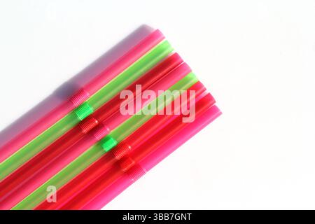 Group of brightly colored plastic drinking straws on a white background Stock Photo