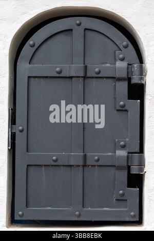 An old gray metal door in a white brick building. High quality photo Stock Photo