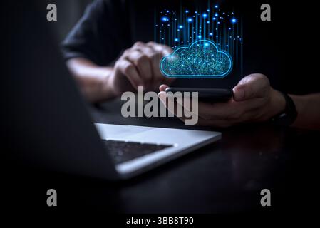 Cloud technology concept showcasing glowing blue cloud icon over smartphone near laptop for seamless data transfer and IT data cybersecurity protectio Stock Photo