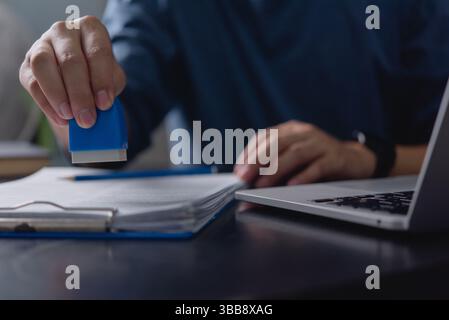 Business approval process, office worker stamping document, paperwork authorization, contract verification, legal document approval, corporate adminis Stock Photo
