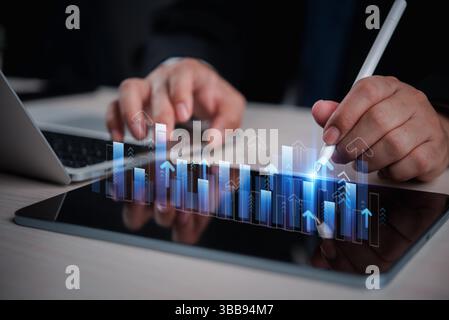 business man analyzing digital financial charts and growth trends on a tablet, highlighting the role of technology and data analysis in modern market Stock Photo