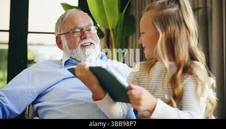Relax, grandfather and child with tablet in home for educational online video, cartoon app or weekend visit. Love, old man and happy girl with digital Stock Photo