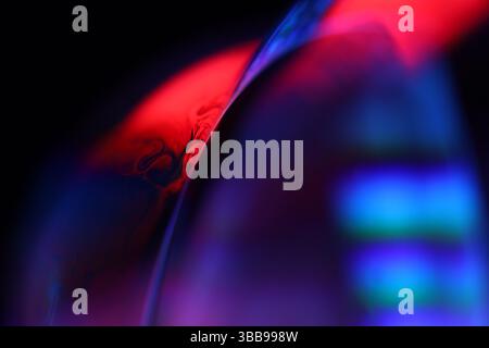 Purple and red liquid on dark background, perfect liquid shapes, glossy reflection Stock Photo