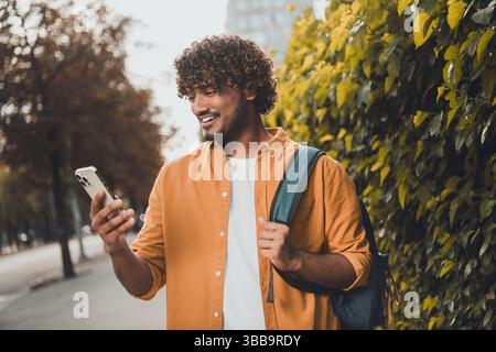 Photo of positive nice man arab traveling city watching map gps navigation spring season weather outside Stock Photo