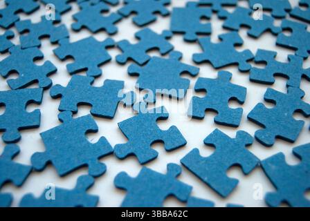Blue jigsaw puzzle pieces close-up. Blue puzzles on white. Jigsaw puzzle background. Challenge and solution concept. Teamwork. Stock Photo