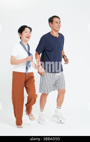 elderly couple running hand in hand​ Stock Photo