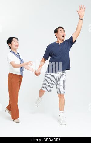 elderly couple running hand in hand​ Stock Photo