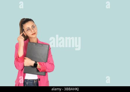 caucasian brunette thoughtful businesswoman scratching her head with her pencil holding organizer clipboard. Looking copy space, thinking project Stock Photo