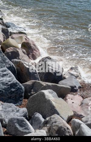 Rocks polished by the pounding of the ocean on the beach at Sidmouth, Devon, UK Stock Photo