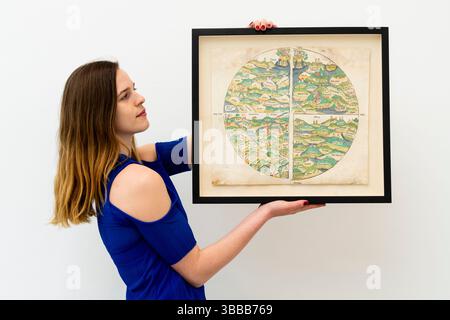 An exhibitor holds up the earliest printed map of the world from 1475 available at Daniel Crouch Rare Books during a preview of the Firsts London book fair, which opens today at the Saatchi Gallery in King's Road, London. Books in Bloom is this year's theme for Firsts London, the UK's leading international rare book fair, with over 100 dealers from around the world bringing a wide range of rare books, manuscripts, maps and prints, with a showcase of floral and botanical examples from print history, from early herbals to contemporary art books and runs until Sunday. Picture date: Thursday May 1 Stock Photo