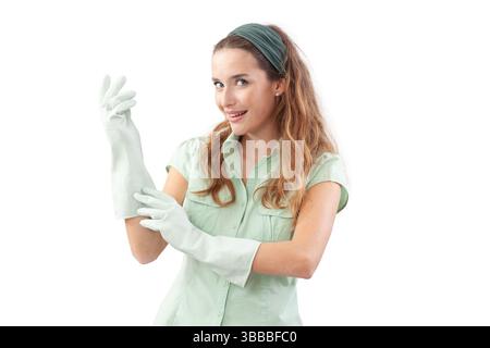 Smiling woman wearing rubber gloves for house cleaning and looking at the camera. Front view, isolated on white background. Concept of hygiene, domest Stock Photo