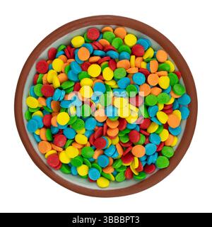 Top view of colorful round cake sprinkles in a small bowl on a white background. Stock Photo