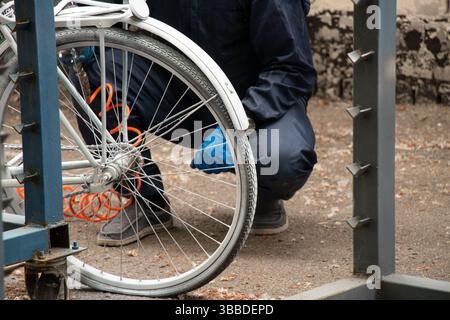 Painting an old bicycle with an airbrush outdoors in white, bicycle restoration, paint Stock Photo