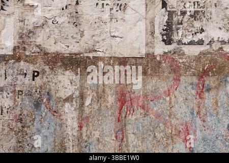 grunge ripped poster on rusty iron sheet background - texture of torn advertisement on an old billboard panel Stock Photo