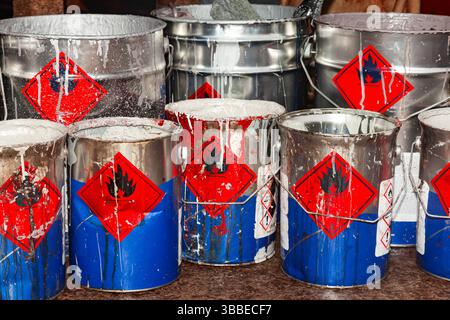Empty paint buckets containing used rollers and brushes. Stock Photo