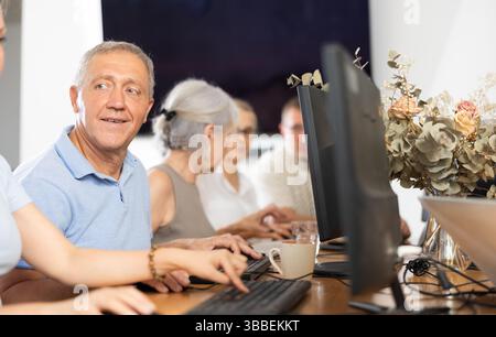 Old man learning computer programs in training room Stock Photo