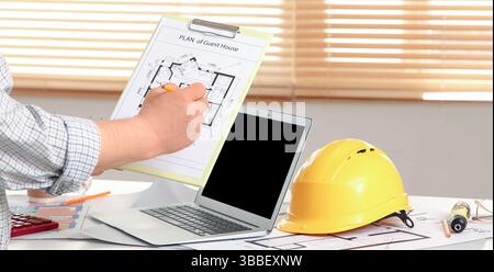 Male constructor working with house plan in office Stock Photo