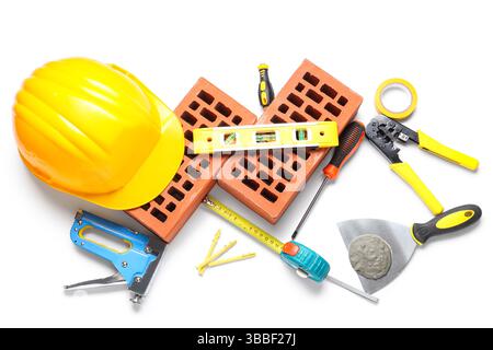 Hardhat, bricks and construction tools on white background Stock Photo