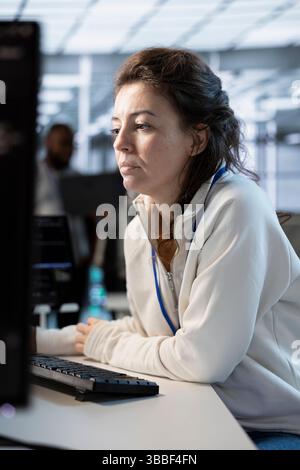 System administrator in server hub implementing power management solutions to reduce energy consumption. Employee integrating new technologies and systems in data center facility Stock Photo