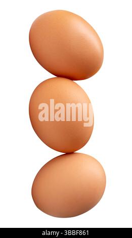 Three fresh brown chicken eggs in stack is isolated on white background with clipping path. Stock Photo